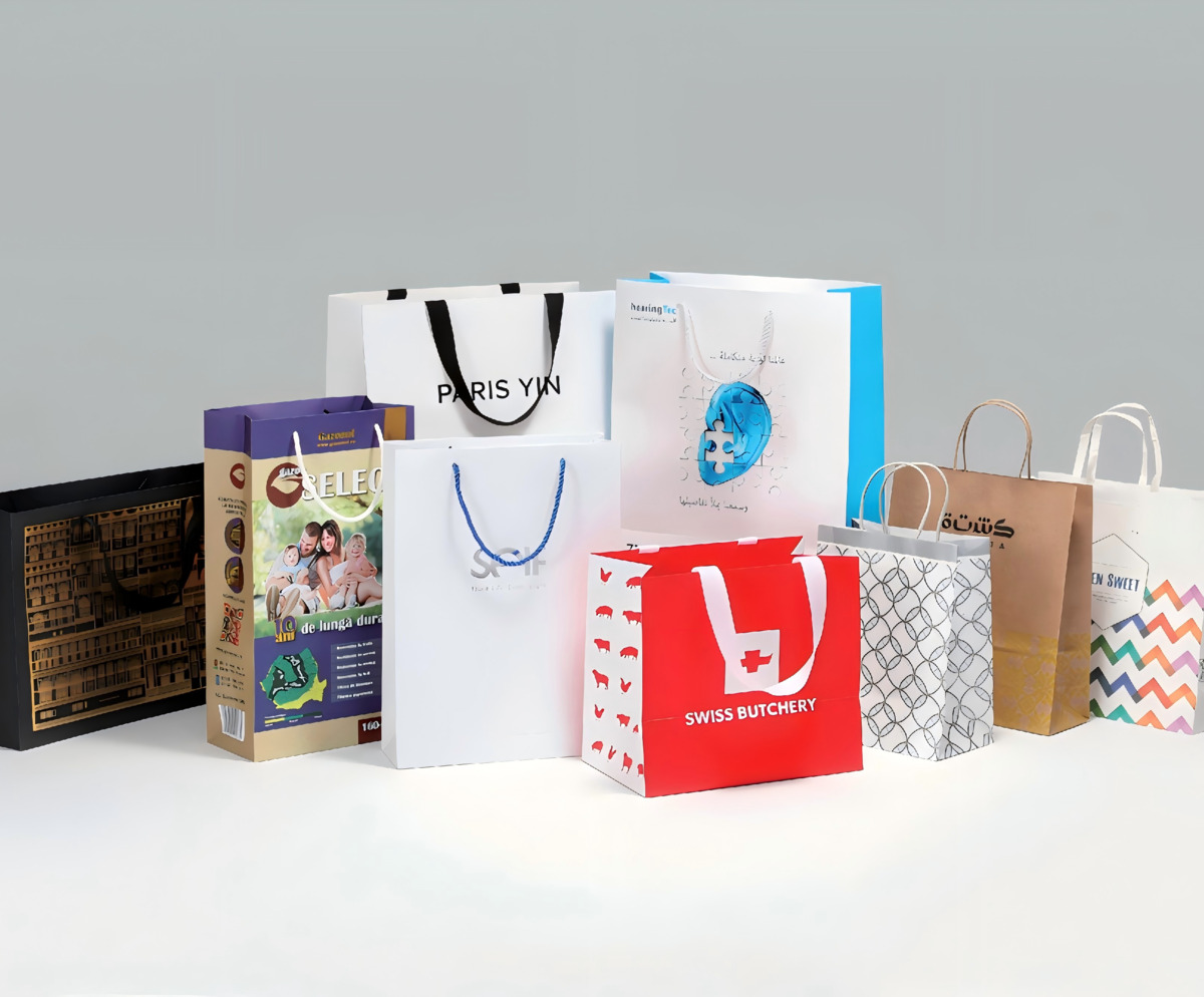 Premium shopping bag with ribbon handles and gold foil logo on marble counter