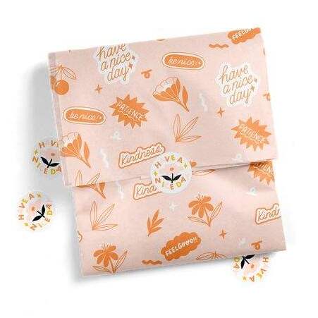 Close-up of hands unfolding custom illustrated tissue paper