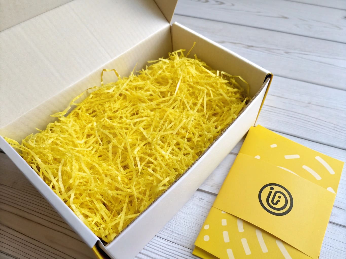 Subscription box with bright yellow shred matching brand logo